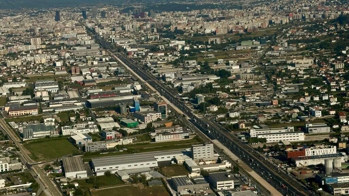 Cyclists riding together along a tree-lined boulevard in central Tirana