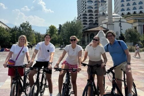 a group of travelers on a bike tour at skanderbeg square by bike tirana